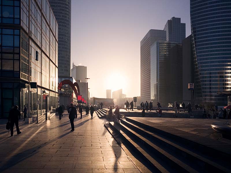 People walking outside the office building during sunset