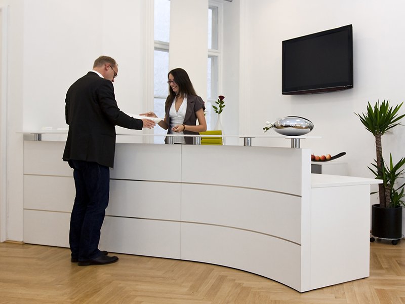 A woman at reception area attending a man