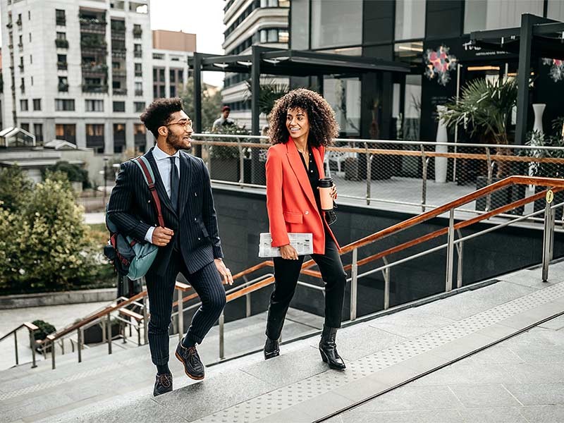 Two business people walking up stairs to the office