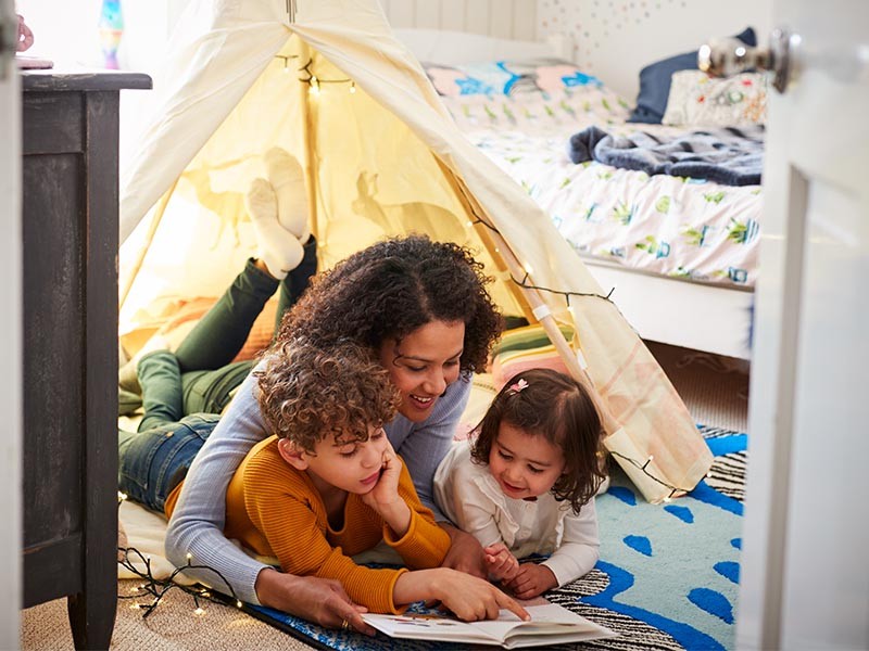 woman with children reading a book