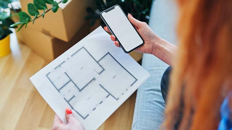 Women with mobile, apartment floor plan
