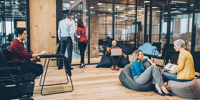 A group of employees work together in a modern workplace lounge area