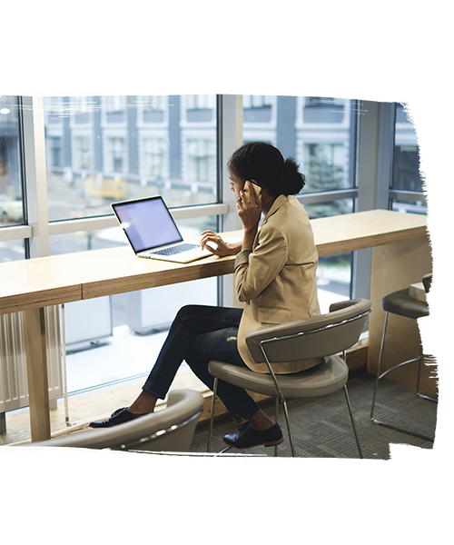 Girl talking on Phone and using her Laptop