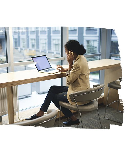 Girl talking on Phone and using her Laptop